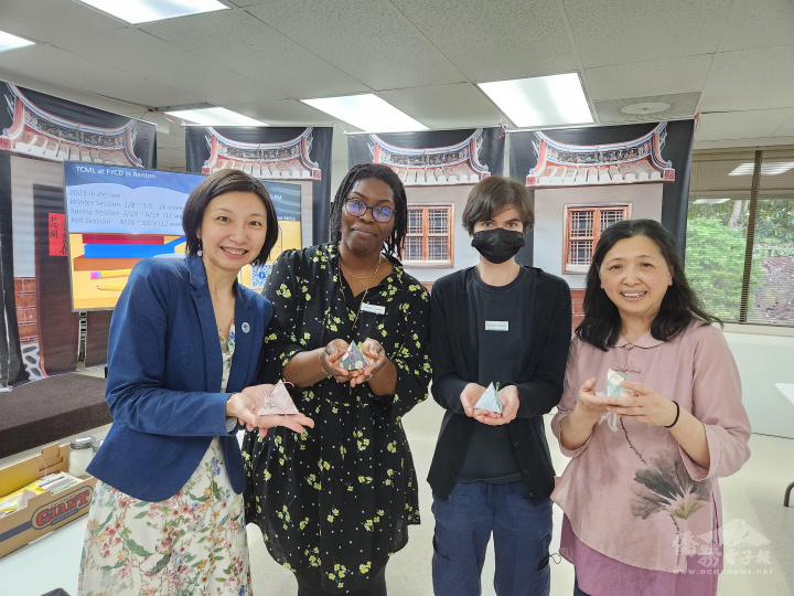 西雅圖文教中心主任吳曉竹(左)與林惠伶(右)與學員們展示手作粽子成品