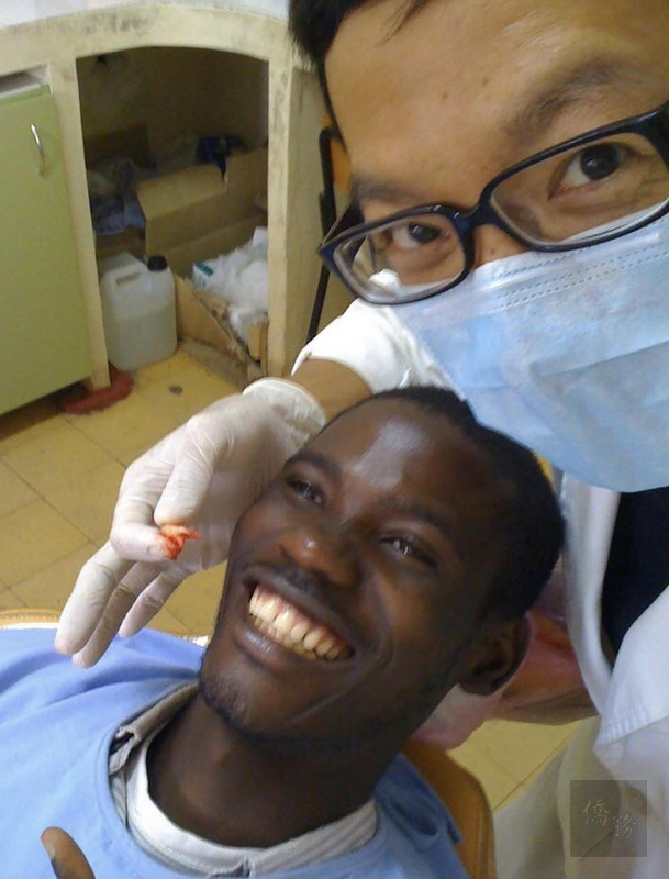 台北醫學大學附設醫院口腔外科醫師祁力行(右)曾長駐史瓦帝尼,幫助當地100名車禍傷者重建顎骨。圖為幫病人拔牙。(祁力行提供)