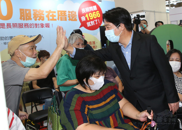 副總統賴清德（前右）30日在南港展覽館出席台灣輔具暨長期照護大展開幕典禮並參觀展場，與身障朋友擊掌打氣。（中央社提供）