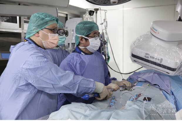 國泰醫院心血管中心部副主任黃啟宏 (右)執行「經導管主動脈瓣膜置換手術(TAVI)」。(國泰醫院提供)