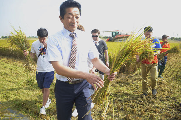 日本北海道名寄市道北農業協同組合代表理事東野秀樹（前），26日帶領4名日本青年農民參訪嘉義縣太保市的有機米收割。（中央社提供）