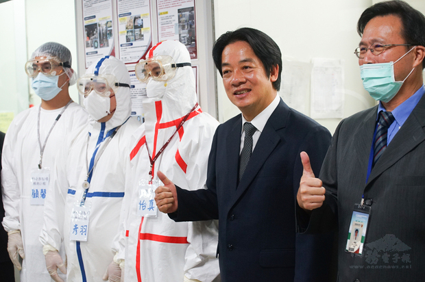 副總統賴清德（右2）3日到紡織產業綜合研究所參訪，瞭解防護衣的檢測流程，並與穿著防護衣的示範人員合影。（中央社提供）