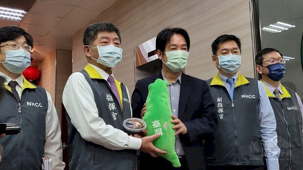 副總統賴清德(中)致贈指揮中心指揮官陳時中(左2)龜苓膏、抱枕 ,盼台灣「疫情歸零、高枕無憂」。