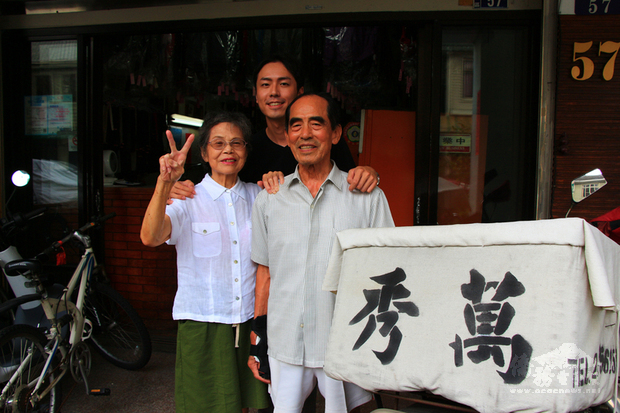 經營萬秀洗衣店的張萬吉（右）與許秀娥（左），在孫子張瑞夫（中）鼓舞下，穿上店內客人遺留的無主衣拍照並上網分享，意外引發外媒關注。（中央社提供）