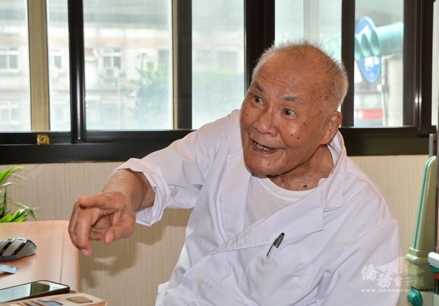 行醫76年的102歲人瑞醫師陳奎村（田中旨夫）仍在診所守護著民眾健康。他微笑說，長壽秘訣是永保身心愉快，不要有煩惱。（中央社提供）