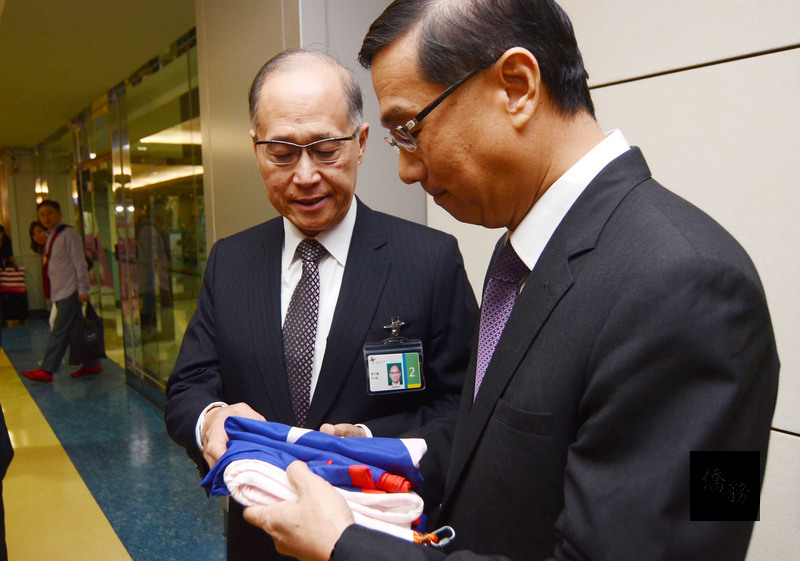 駐巴拿馬大使曹立傑（右）17日返台，他帶回在巴國所降下的中華民國國旗，交給接機的外交部長李大維（左）。（中央社提供）