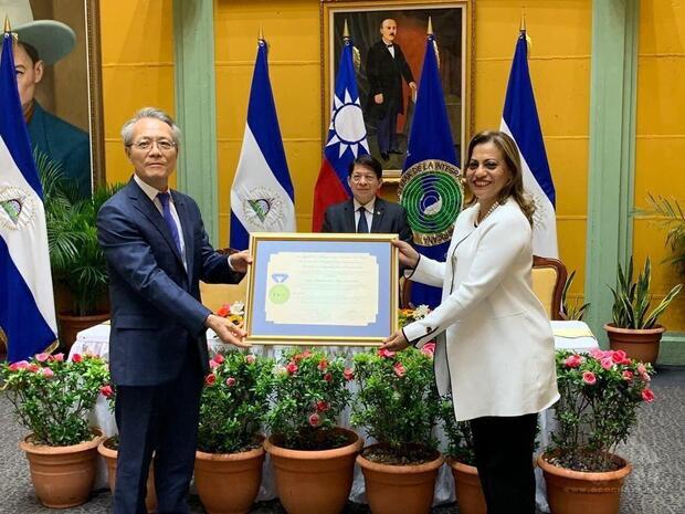 駐尼加拉瓜大使吳進木代表我國政府接受中美洲統合體(SICA)輪值主席國尼加拉瓜家庭部長Johana Flores頒贈「推動社會統合之友」獎章。（外交部提供）