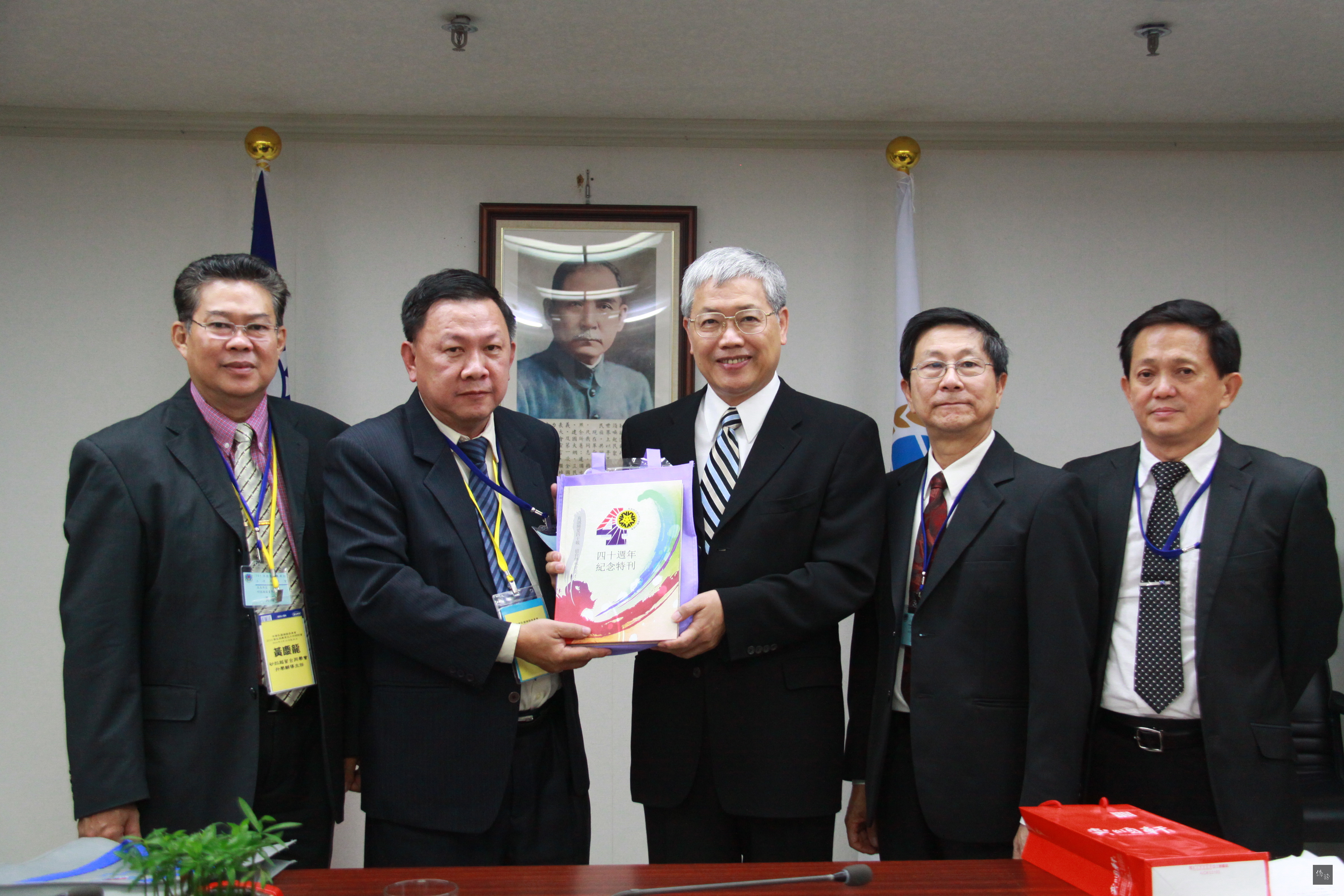 「103年僑生保薦單位工作研討會」團長魏文地（左二）致贈紀念品給僑務委員會委員長陳士魁（中）。