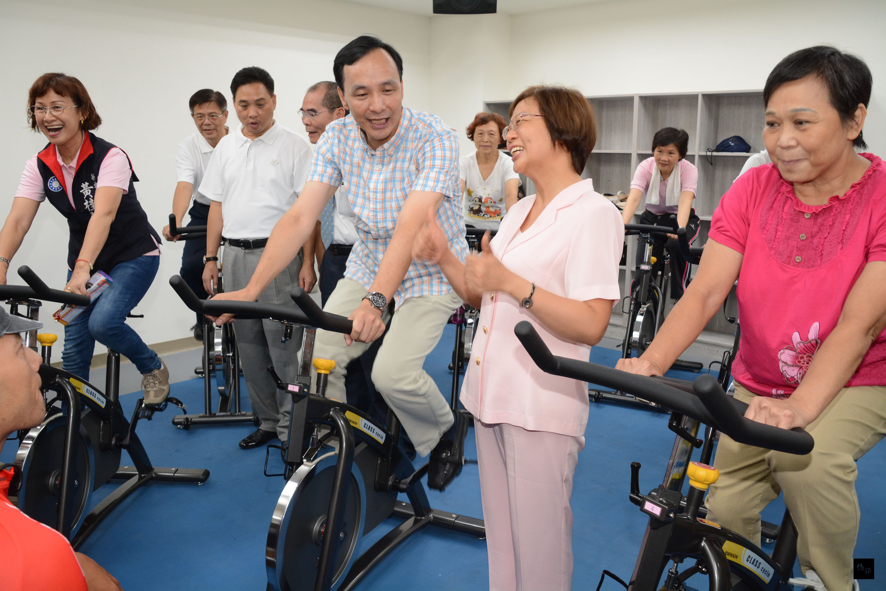 新北市長朱立倫(右三)8月31日參加蘆洲國民運動中心揭幕,親自下場騎飛輪,不少市民爭相合影,場面熱鬧。(中央社提供)