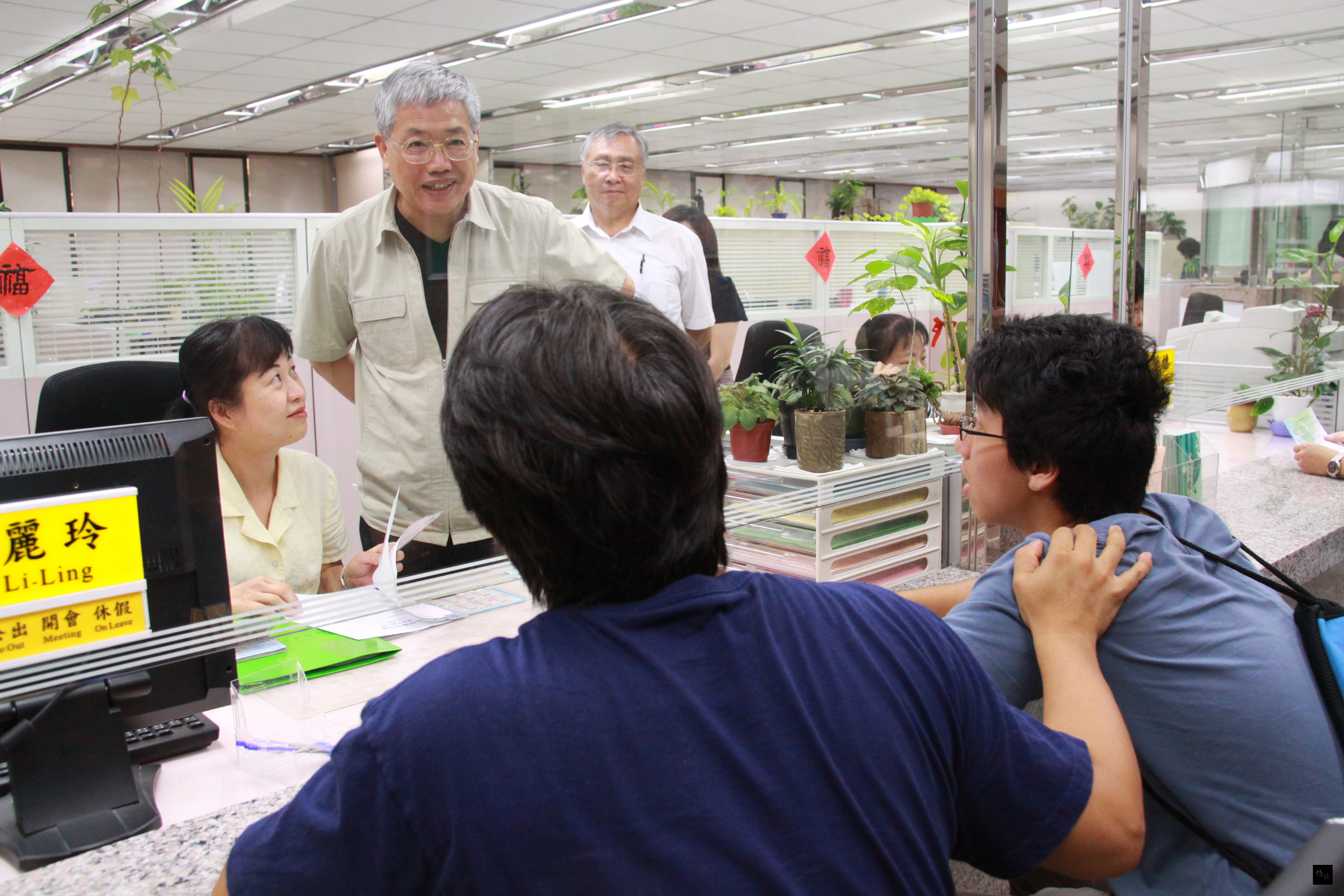 僑委會委員長陳士魁（立者左）巡視為民服務櫃台，關心民眾辦理證照業務情形。