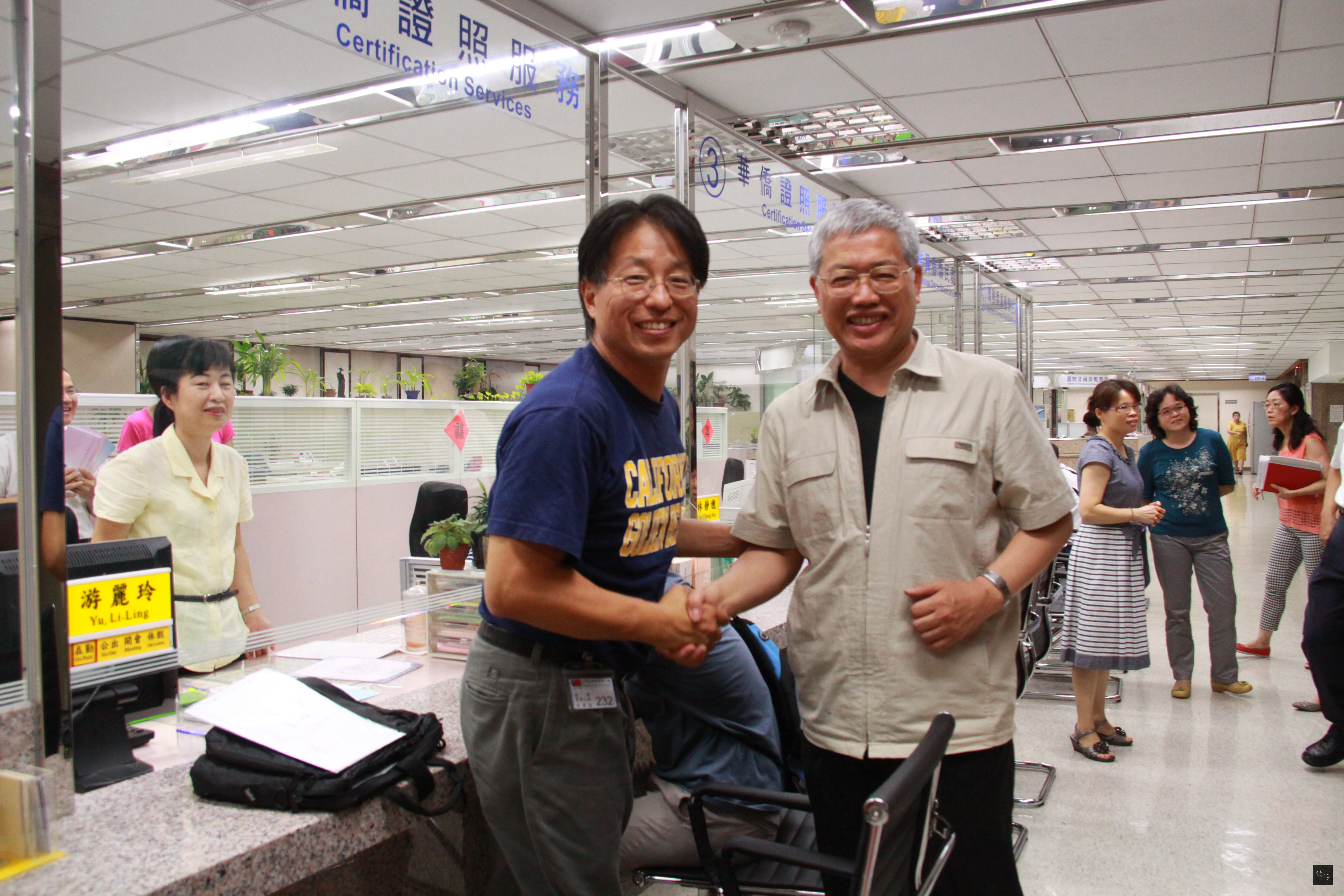 僑委會委員長陳士魁（右）巡視改建完成的為民服務櫃台，向洽公的民眾（左）致意。