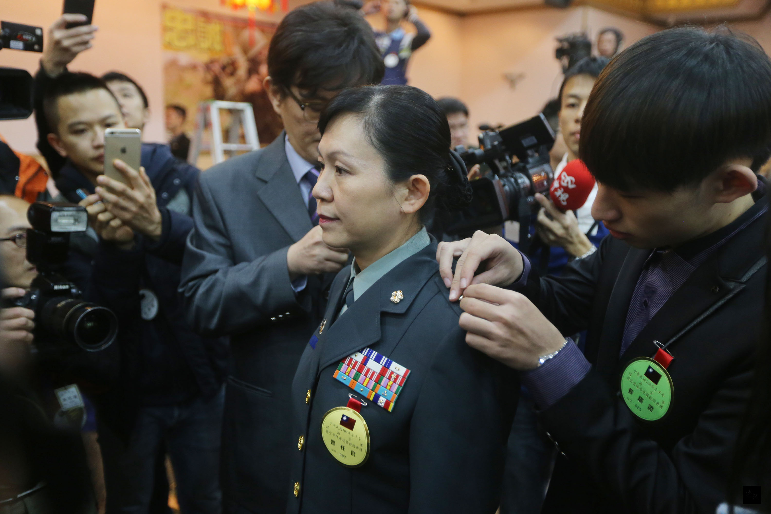 國防部26日舉行104年上半年陸海空軍將官晉任布達暨授階典禮，馬祖部政戰主任陳育琳（中）晉升少將，家人幫她換上新的官階。（中央社提供）