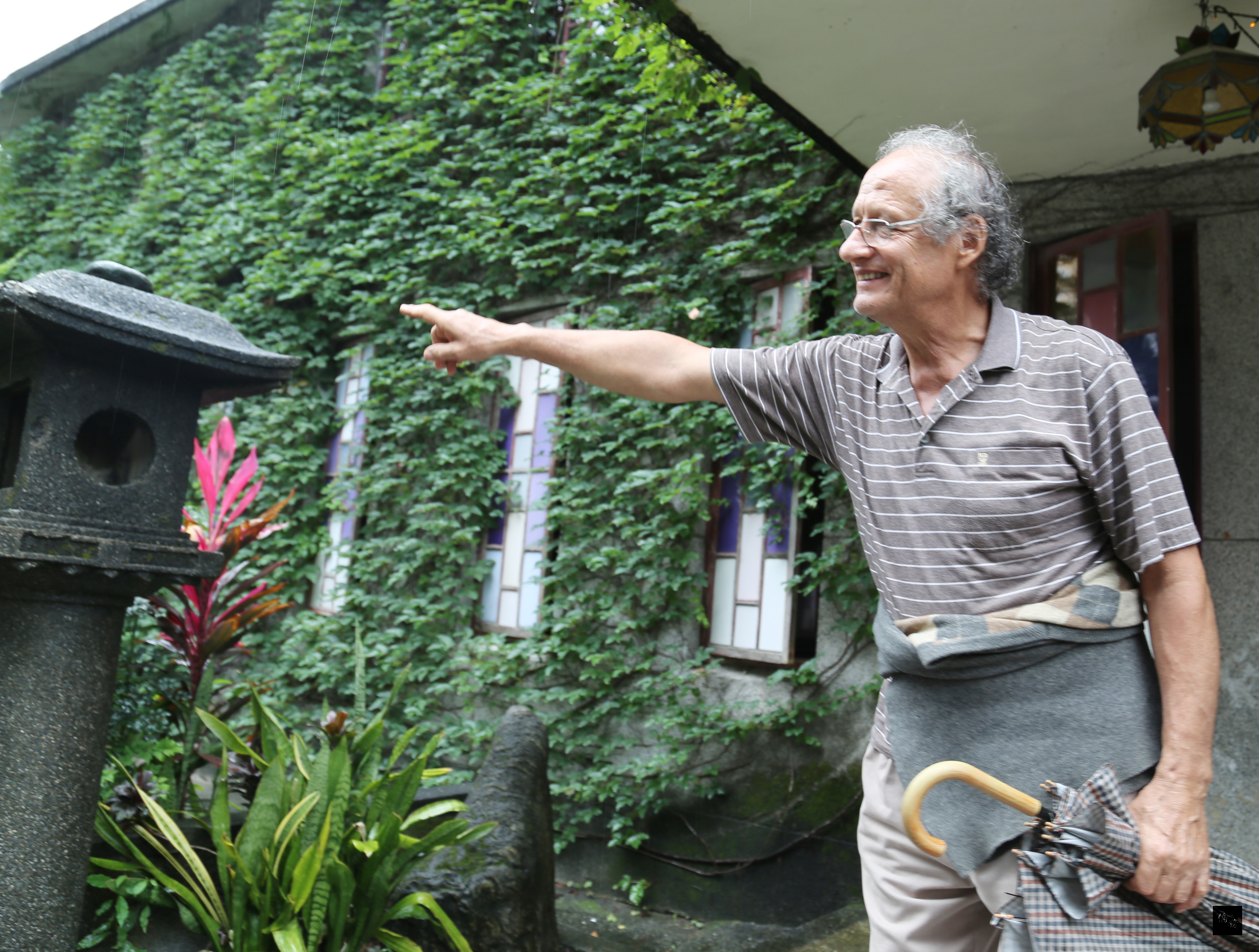 花蓮新城天主堂融合日據時期的神社，雖含兩種不同信仰的建築物，神父戴宏基以開闊的胸襟、歷史的角度致力維護。圖為戴宏基介紹教堂門前一個日本石燈籠。（中央社提供）