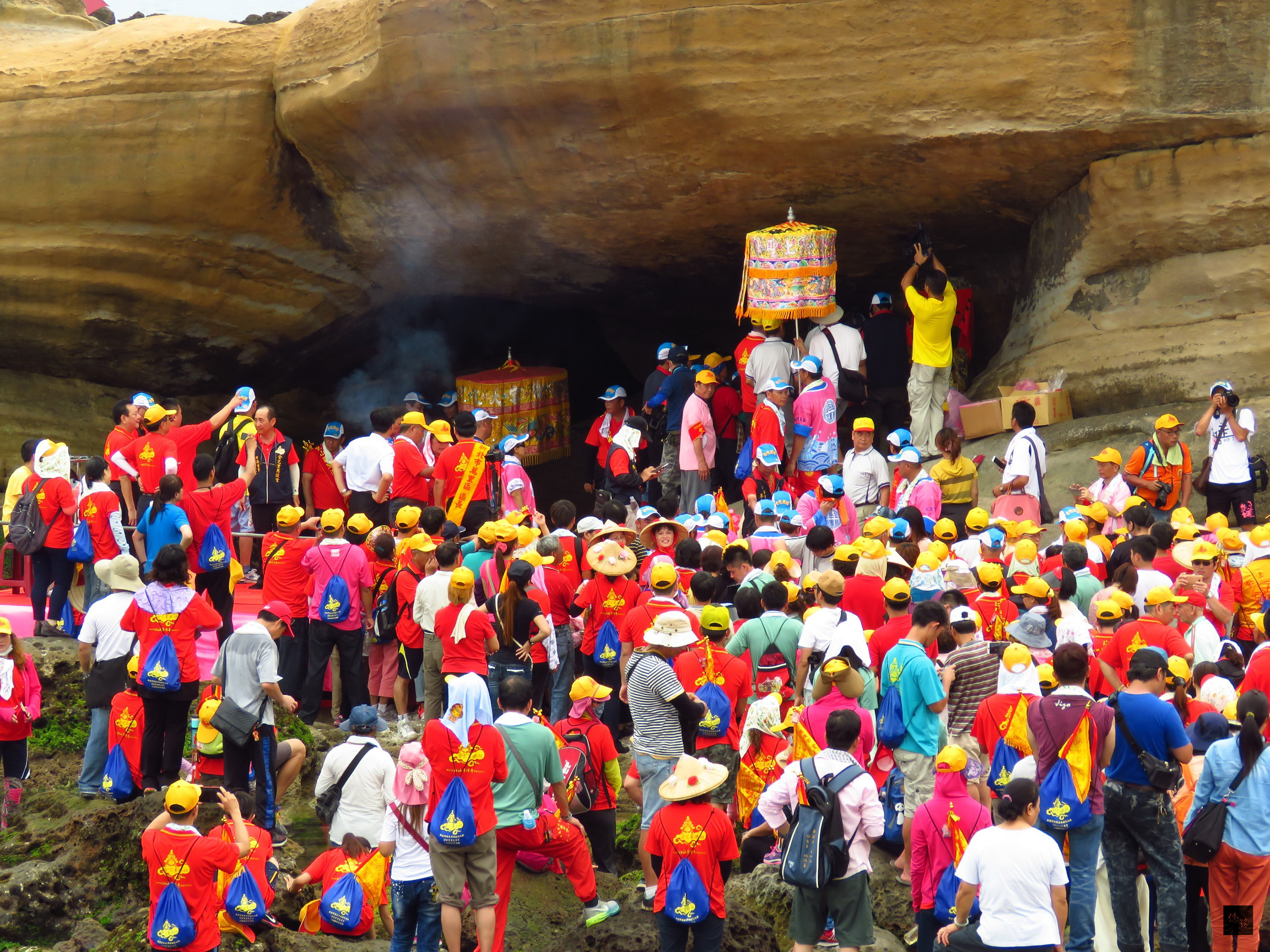 新北市金包里媽祖「回娘家」循古禮舉行,3000名信眾在豔陽下,沿基金公路步行至野柳。被海水淹沒的海蝕岩洞退潮後露出,信眾隨即莊嚴祭拜,祈求媽祖保佑。(中央社提供)