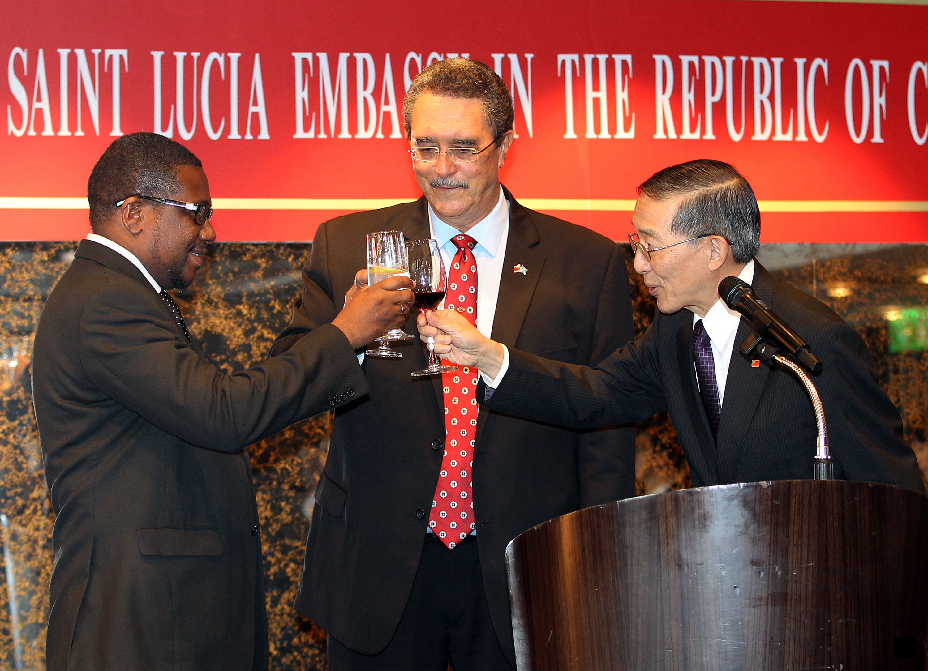 外交部長林永樂(右)在台北出席聖露西亞駐華大使館揭牌儀式,聖露西亞總理安東尼(中)與林永樂共同舉杯慶賀。(中央社提供)