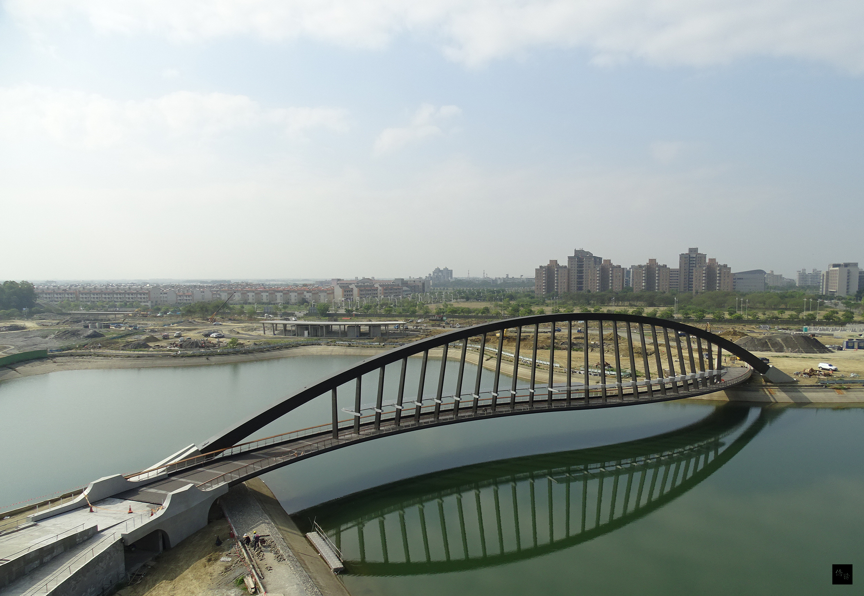 營建署10日表示，國立故宮博物院南部院區工程跨越景觀湖長達141公尺鋼構景觀橋，在4月15日竣工，壯麗的拱橋結構像彩虹出現在天際。（中央社提供）