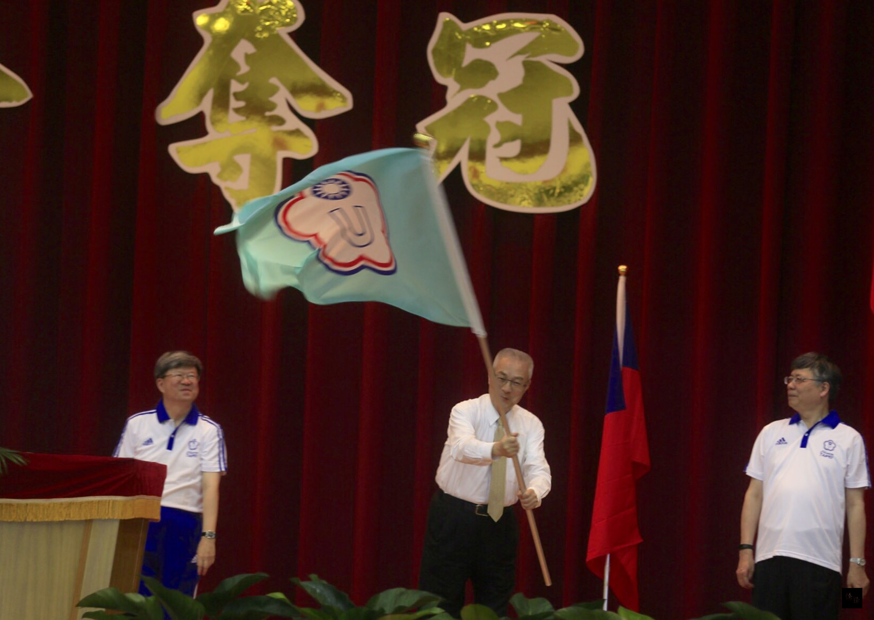 副總統吳敦義(中)25日出席高雄國訓中心「韓國光州世界大學運動會」中華隊代表團授旗典禮,將團旗授與代表團團長江漢聲(右)。(中央社提供)