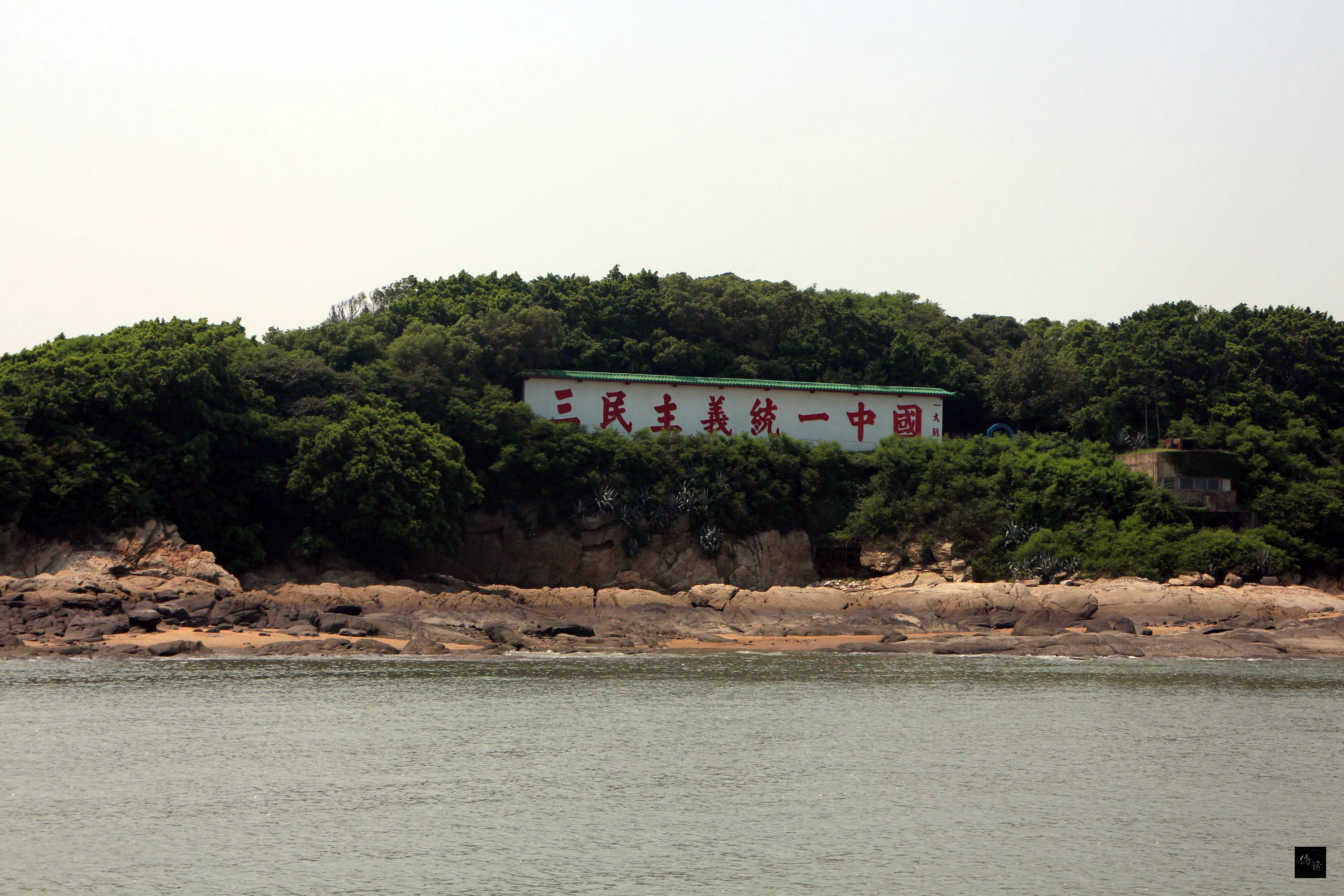 47名旅客4日搭乘遊艇,從海上欣賞金門,感受金門另類的美。旅客最期待的是看到大膽和二膽,兩岸遊客競相搶拍大膽島上知名的標語「三民主義統一中國」。(中央社提供)