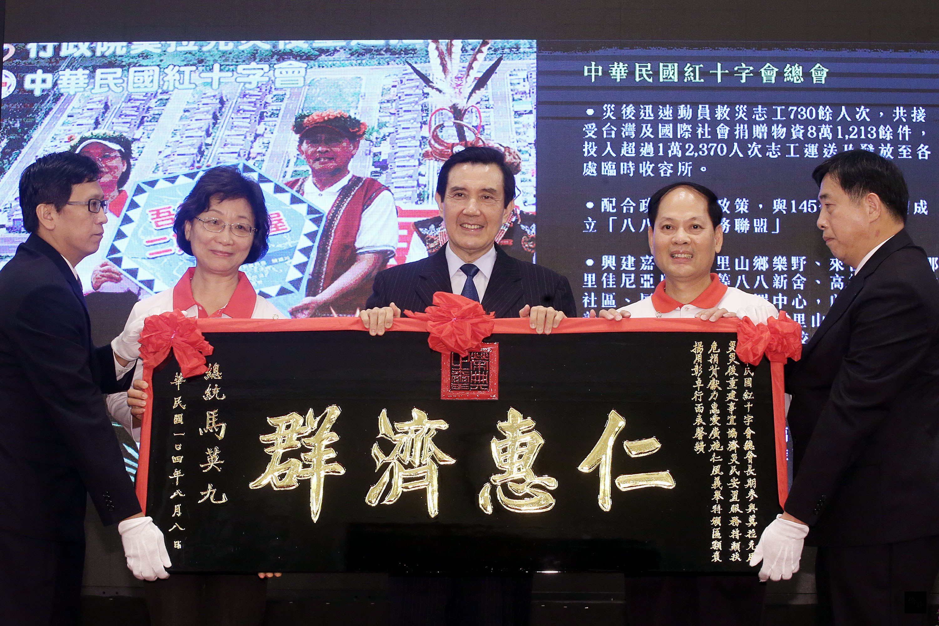 「八八水災」屆滿6週年，總統府8月28日舉辦「莫拉克風災重建有功人員暨團體表揚活動」，總統馬英九（中）贈匾褒揚中華民國紅十字會總會，表達感謝。左二為中華民國紅十字會總會長王清峰。（中央社提供）
