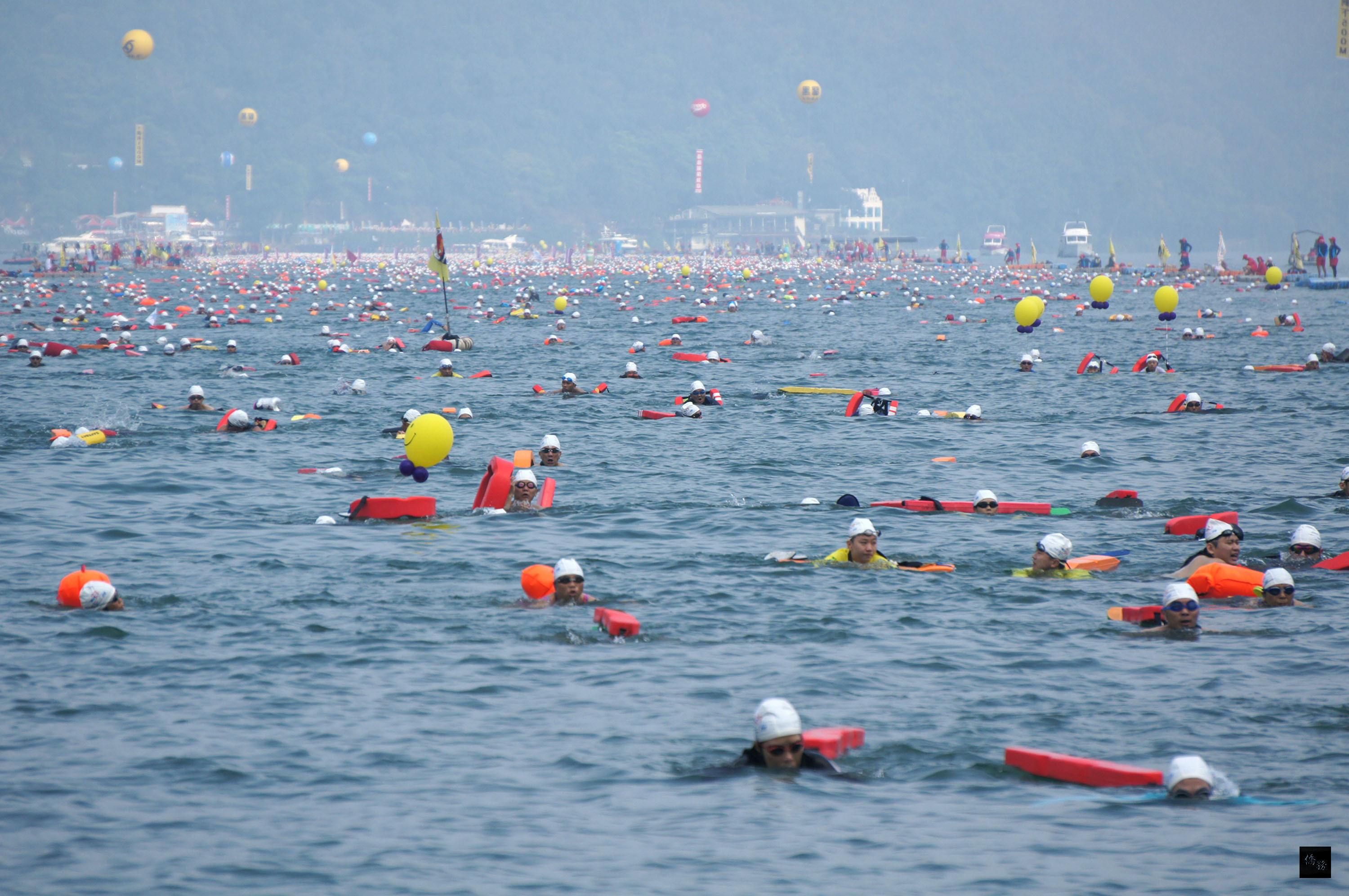 萬人泳渡日月潭20日登場,約2萬人橫渡3000公尺,有別19日競賽嚴肅氣氛,20日活動為挑戰自我,氣氛歡樂,邊游邊玩樂。(中央社提供)