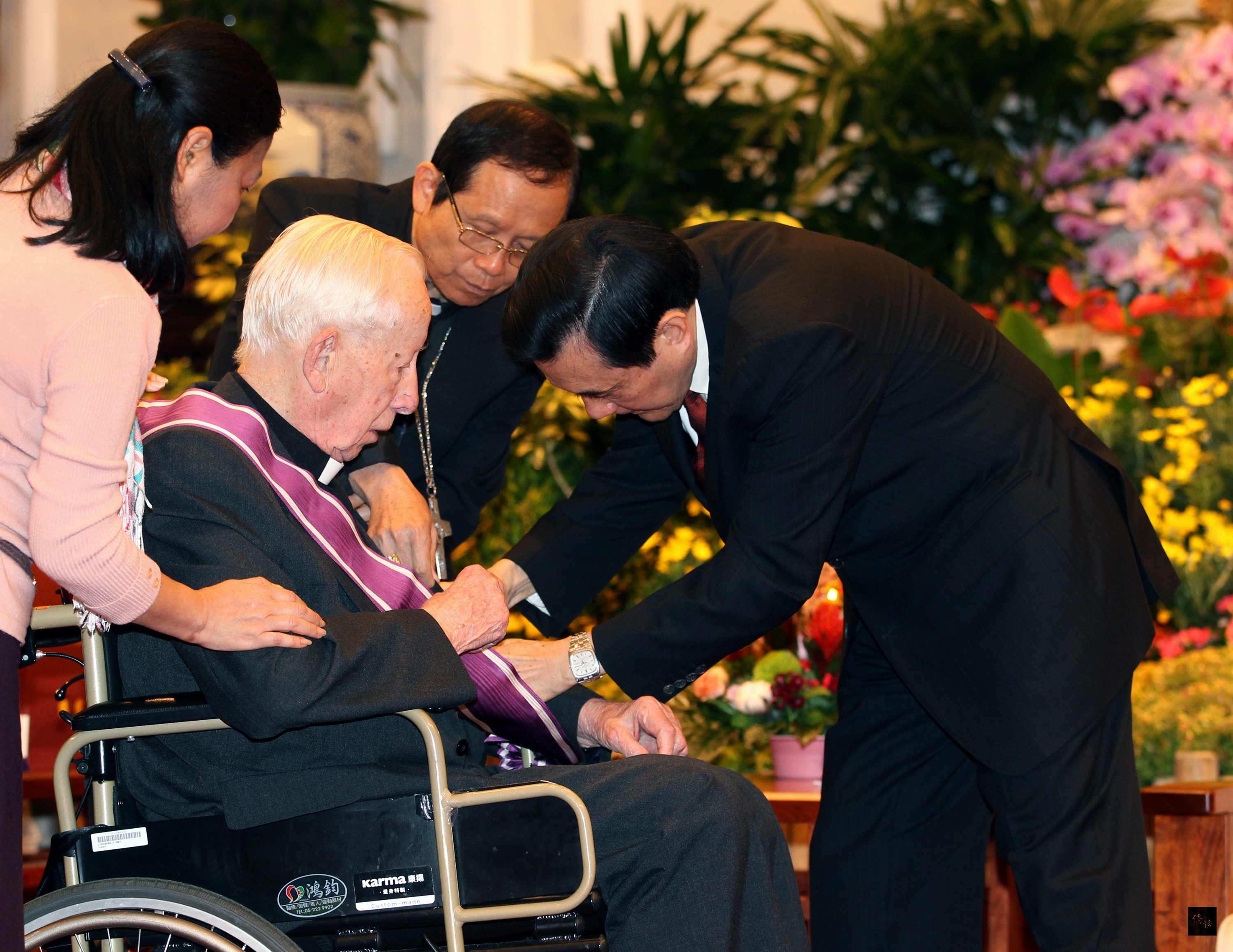 總統馬英九(右)在總統府主持104年外籍宗教人士授勳典禮,頒贈畢耀遠神父(左二)等12人紫色大綬景星勳章。(中央社提供)