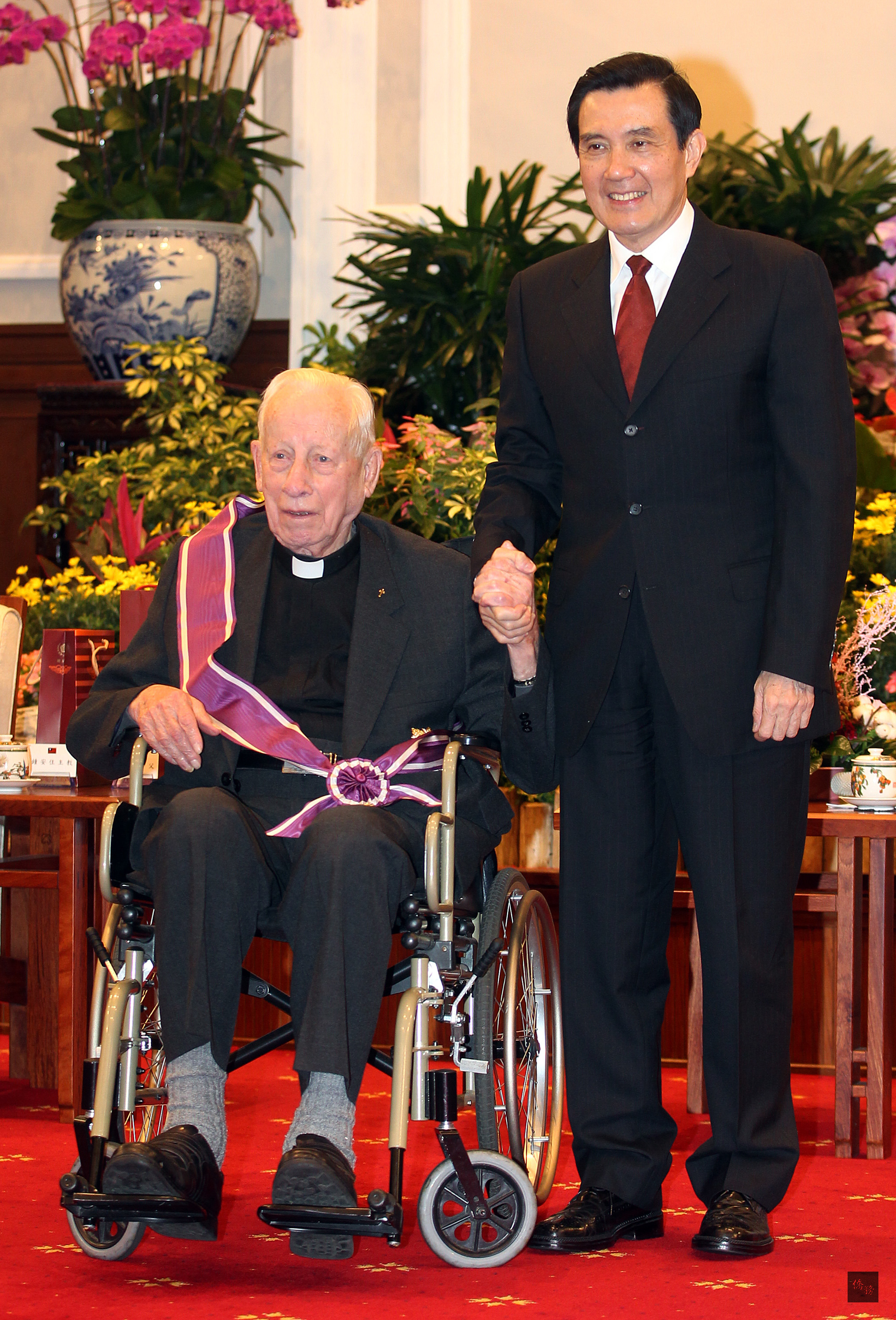 總統馬英九(右)在總統府主持104年外籍宗教人士授勳典禮,頒贈畢耀遠神父(左)等12人紫色大綬景星勳章。(中央社提供)