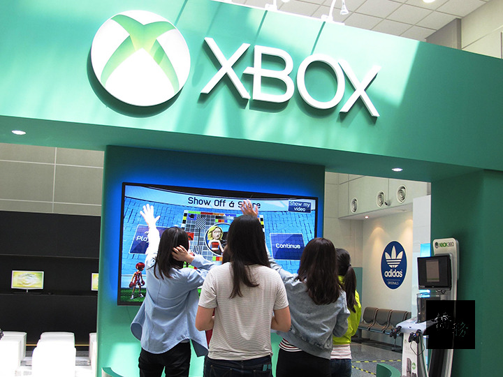 桃園國際機場第二航廈D區電競體驗館有XBOX大型遊戲機,吸引許多旅客駐足。(行政院提供)