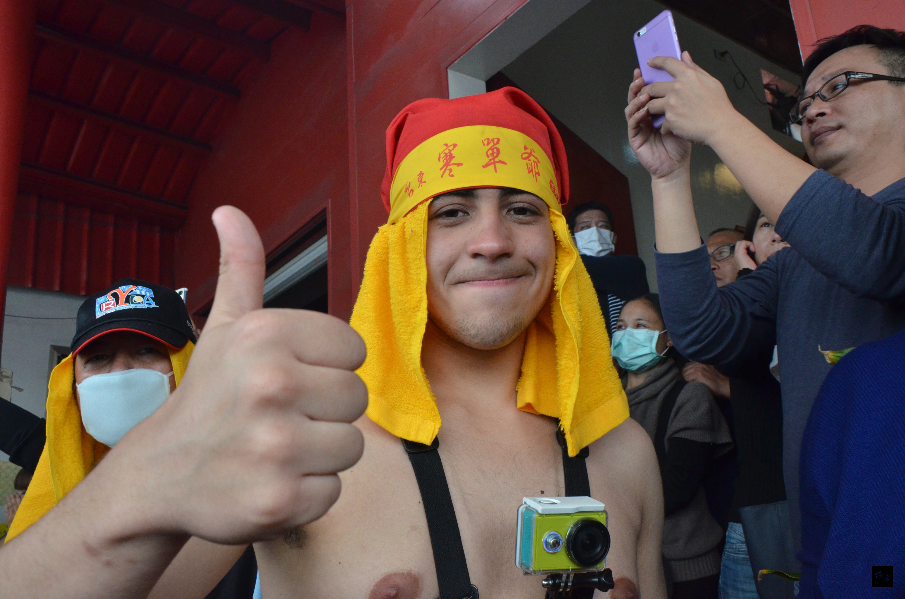 台東元宵重頭戲「炮炸寒單爺」22日連番轟炸，19個國家交換學生體驗炸寒單，來自巴西的丁偉杰奮勇當肉身寒單接受炮炸，他豎起大拇指說有趣。（中央社提供）