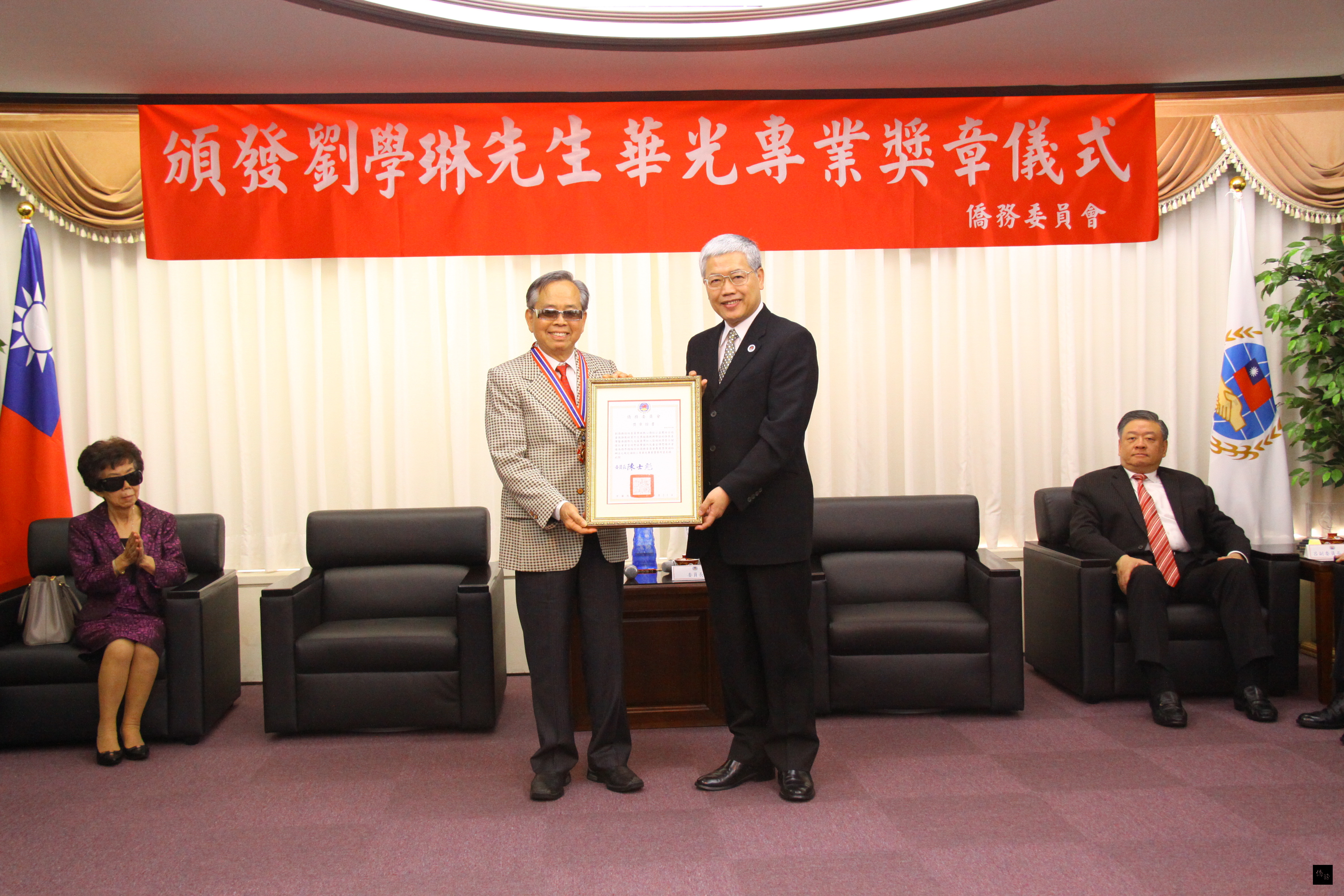 僑務委員會委員長陳士魁(右)頒發華光專業獎章證書給僑務諮詢委員劉學琳(左)。