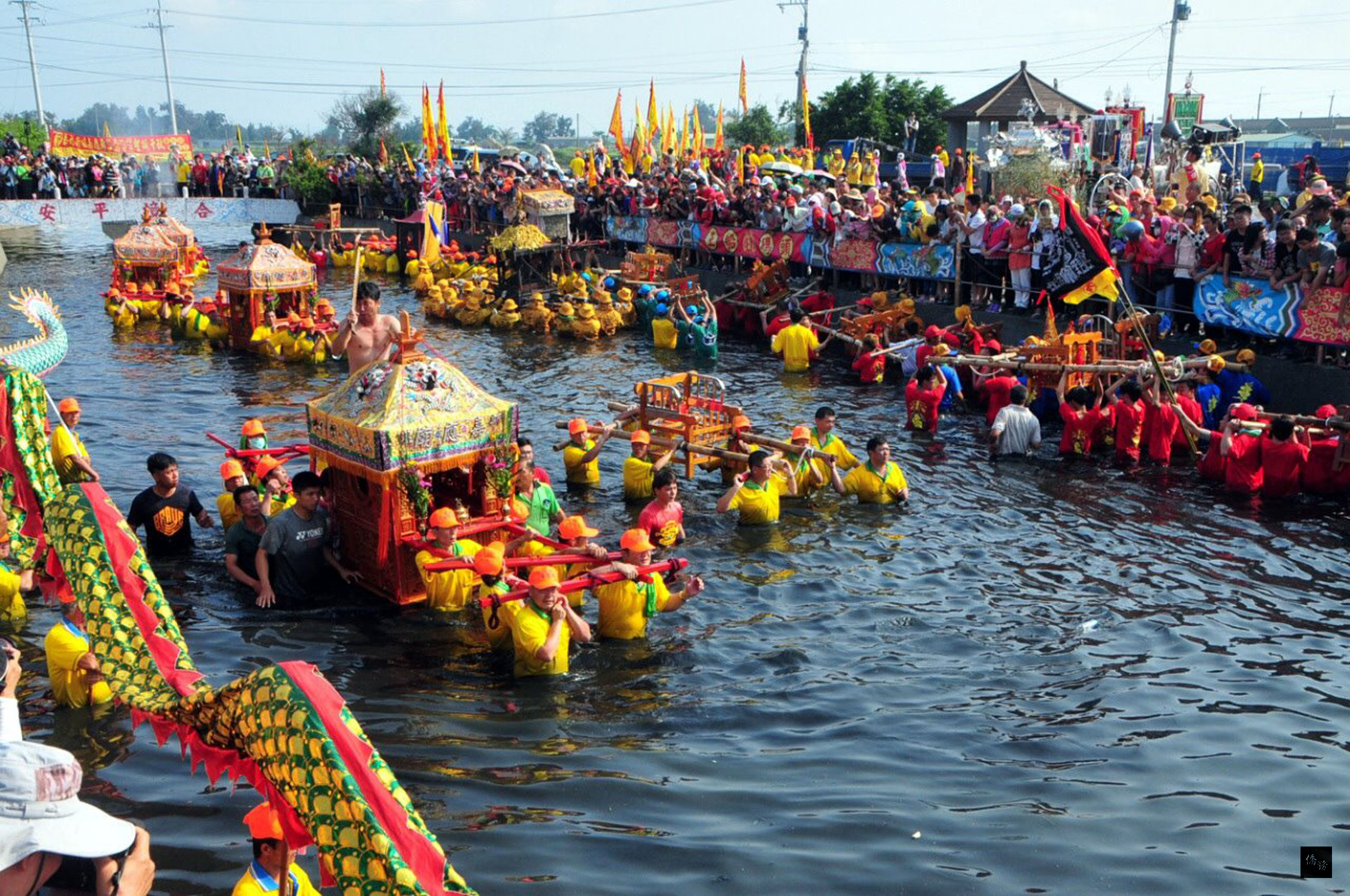 嘉義縣布袋鎮新塭嘉應廟百年傳統民俗「衝水路、迎客王」活動，3日在新塭王船碼頭登場，神轎在震耳欲聾的鞭炮聲中，一一衝進水裡，場面盛大熱鬧。（中央社提供）