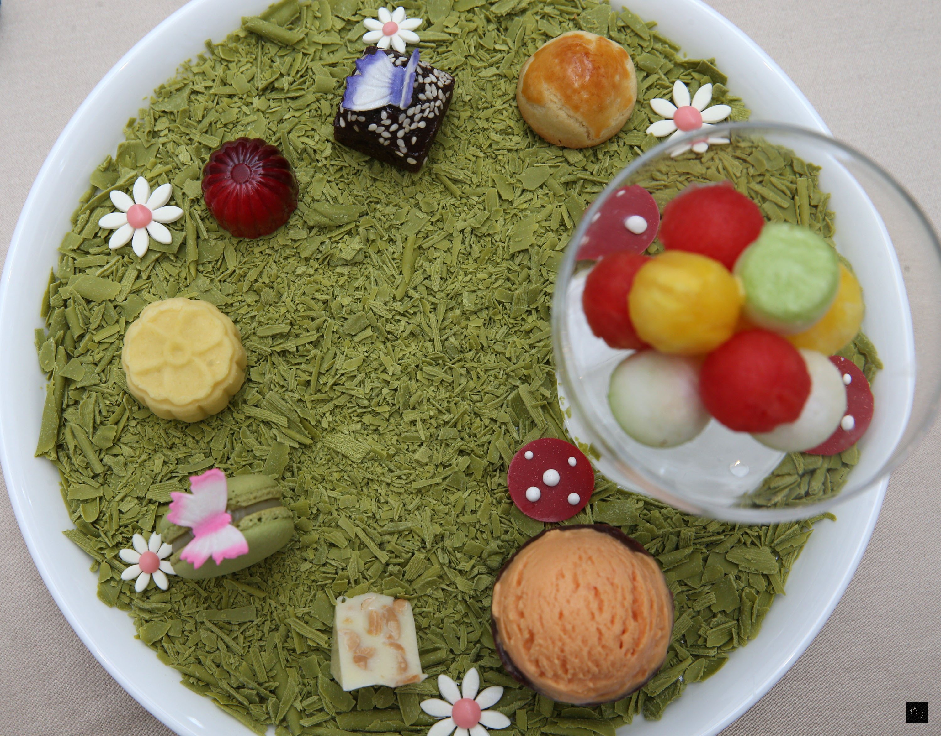 萬豪酒店14日展示國宴甜點料理，利用在地食材推出「花園寶島繽紛盤」，包括黑糖糕、金鑽鳳梨酥、綠豆糕、烏龍茶馬卡龍、牛軋糖、芝麻巧克力、木瓜牛奶冰淇淋。（中央社提供）