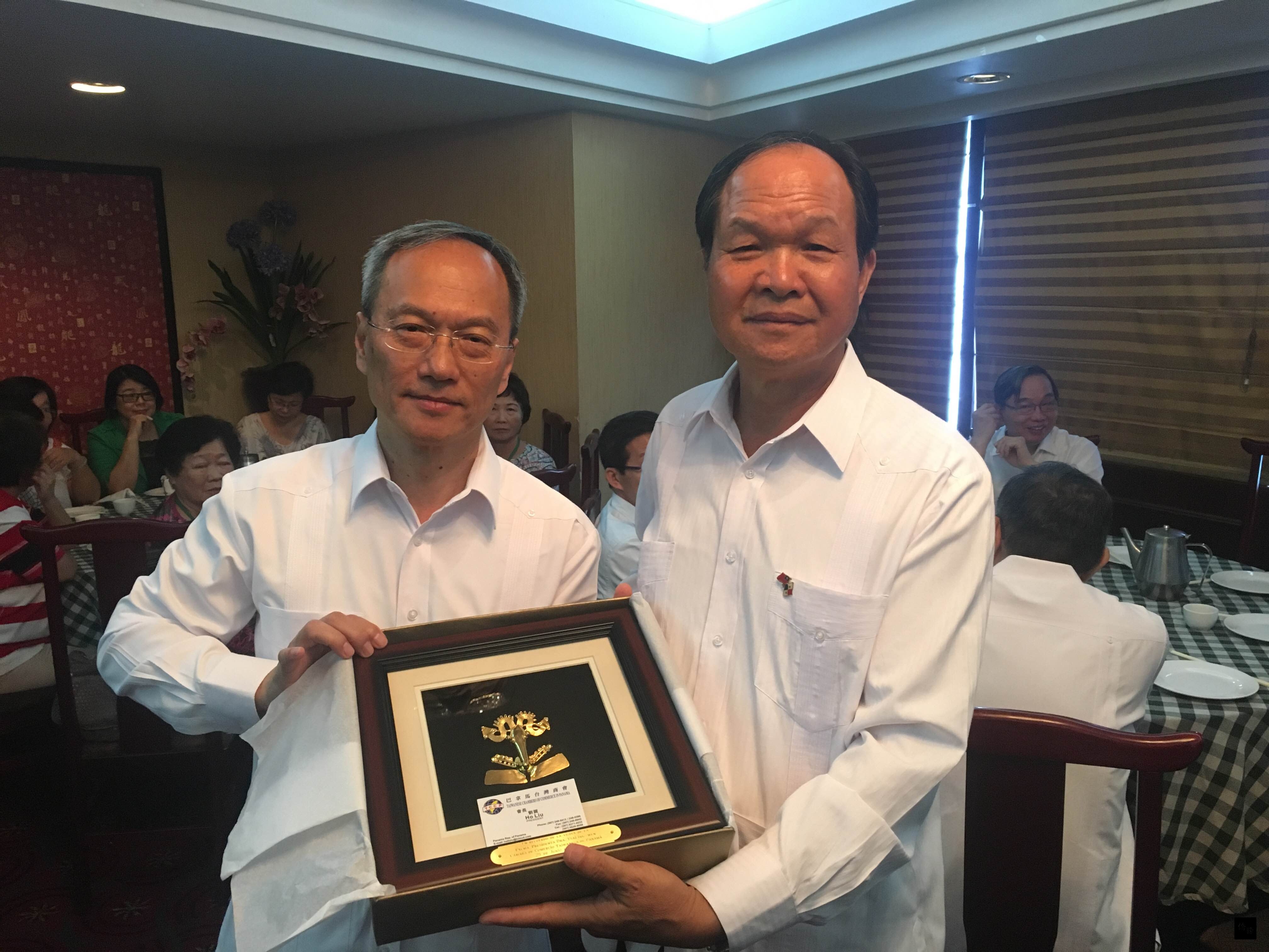 巴拿馬台商會與哥斯大黎加、多明尼加等國台僑聯合設宴歡迎僑務委員會委員長吳新興(左),並由巴拿馬台商會長劉賀(右)代表致贈紀念品。(駐巴拿馬大使館提供)