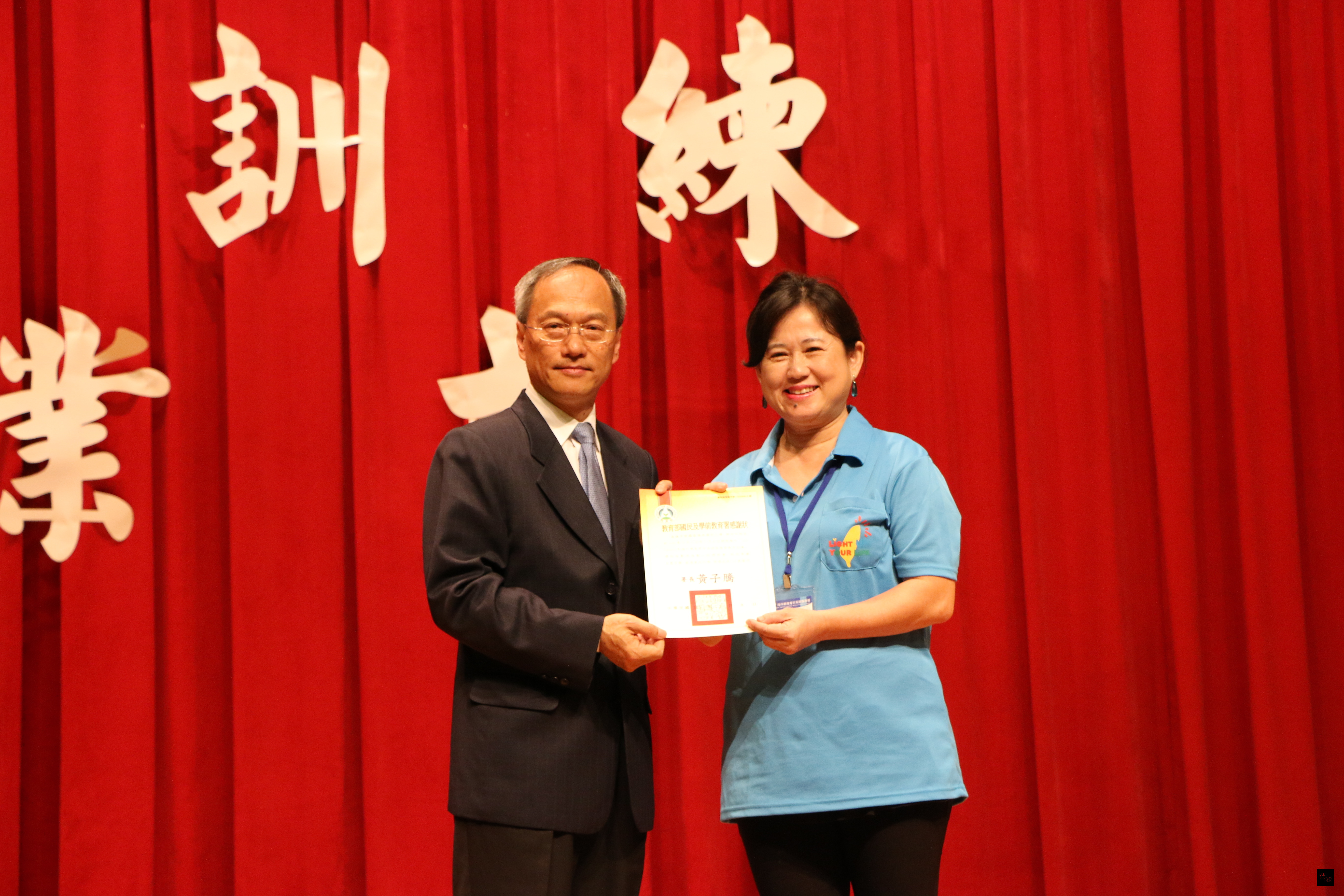 2016年海外華裔青年英語服務營8日上午舉行教育訓練結業式,僑務委員會委員長吳新興(左)頒發感謝狀給高雄市瑞祥國小校長林玲吟(右)。