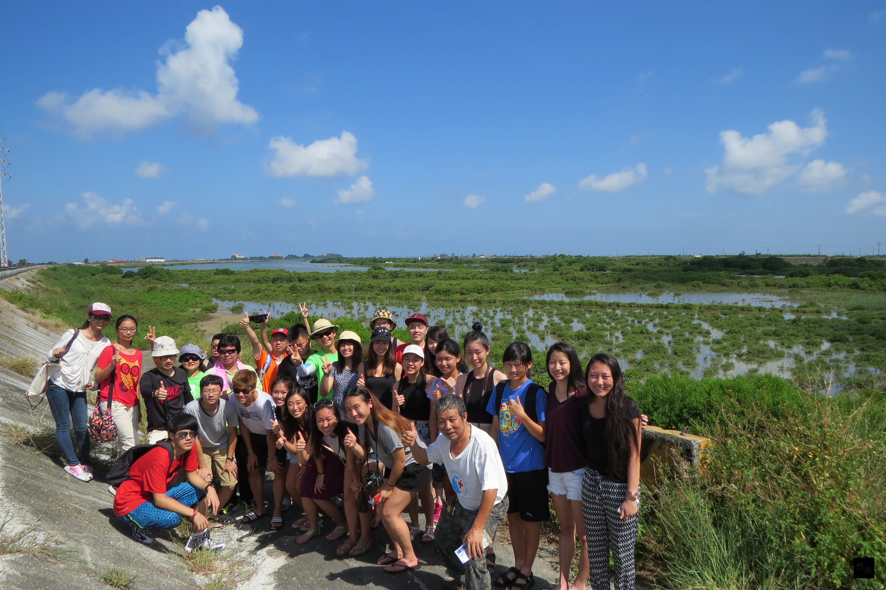 在台南市後壁國小「2016海外華裔青年英語學習服務營」服務的8名美國高中青年,17日利用備課空檔到學甲濕地生態園區參觀,在保育團體人員導覽解說下,認識台南的濕地。(中央社提供)