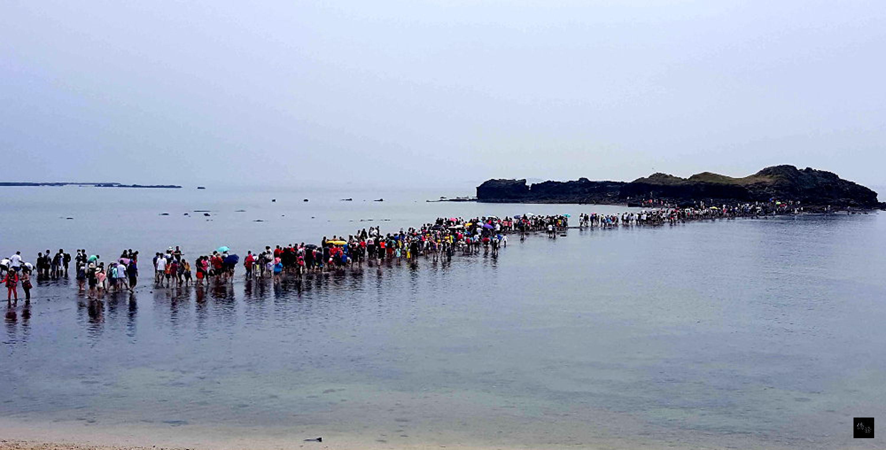 澎湖旅遊最夯的「摩西分海」景點,7月30日遇週休假日,上午同時擁入超過2000名遊客,讓摩西分海變成「摩西人龍」,遊客塞滿整條步道,實地體驗在海底步道踏浪和感受海水的清涼舒暢。(中央社提供)