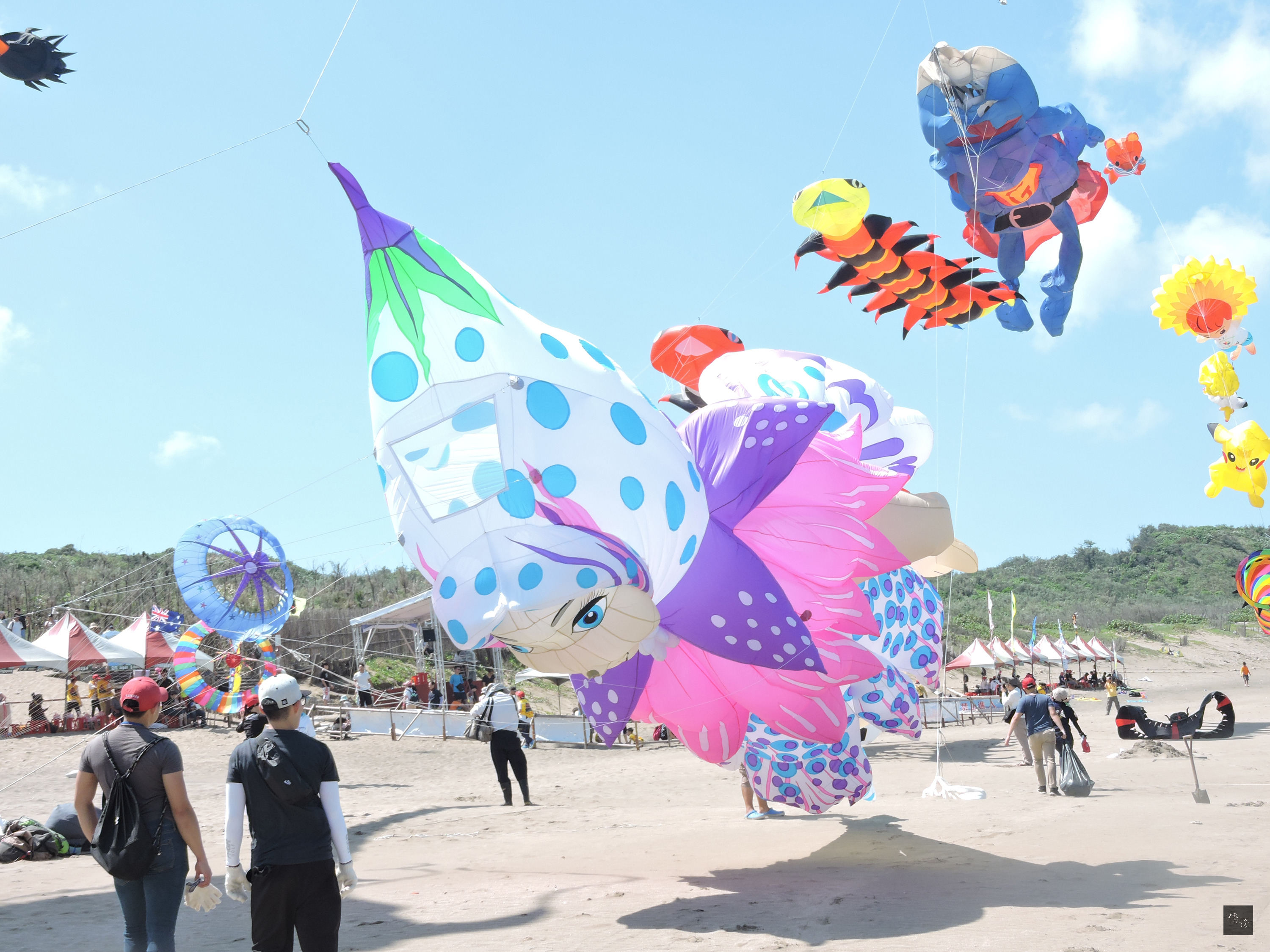 新北市北海岸國際風箏節24日邀世界各國風箏好手齊聚石門白沙灣競技及炫目展演,選手帶來各具代表的風箏,將湛藍的天空妝點得熱鬧非凡。圖為印尼10米小精靈風箏、新加坡毛毛蟲、德國笨蛋超人風箏飛舞。(中央社提供)