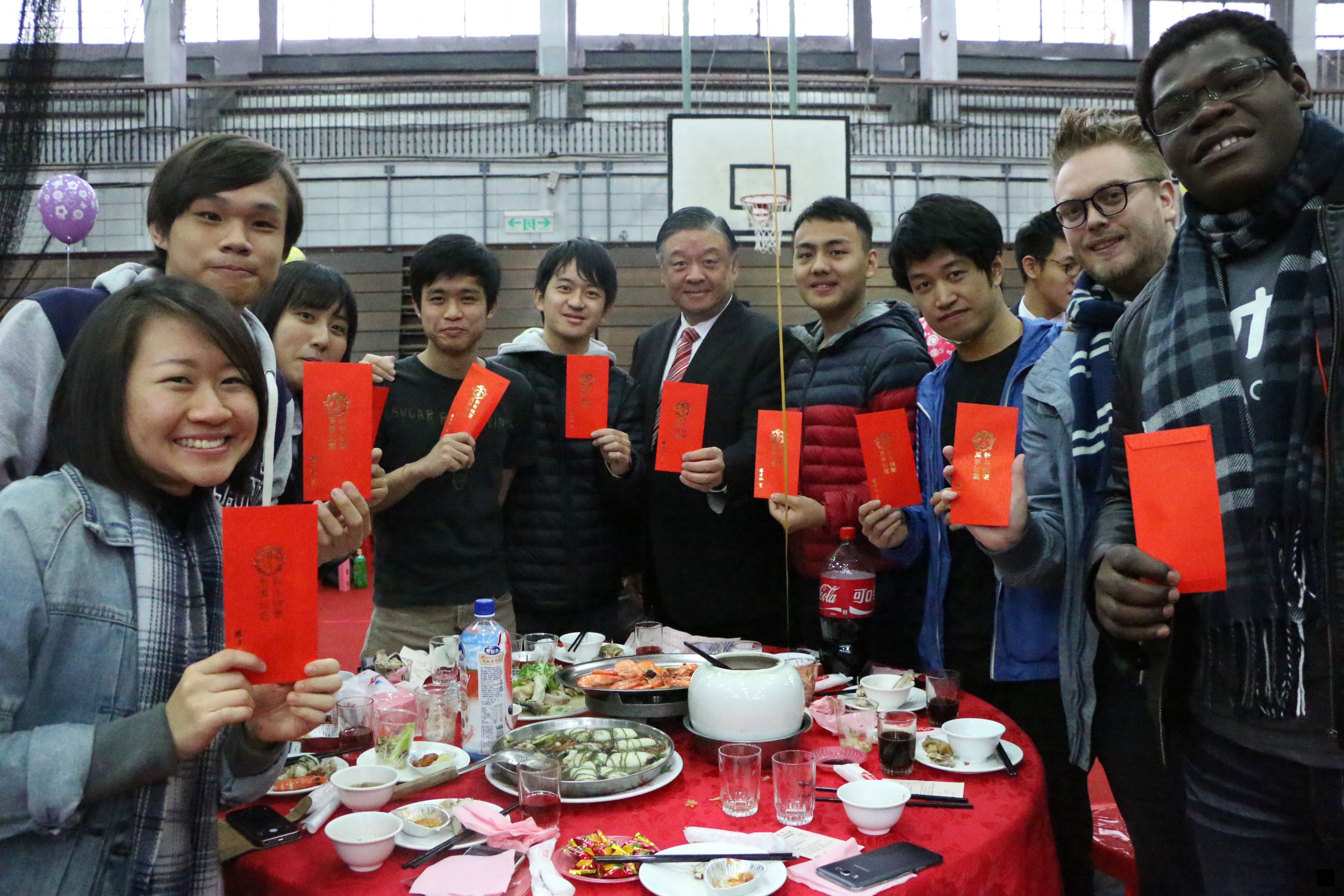國立台灣大學舉辦春節祭祖大典暨師生聯歡餐會，僑務委員會副委員長呂元榮（右五）逐桌發送紅包給同學，預祝大家新年快樂。