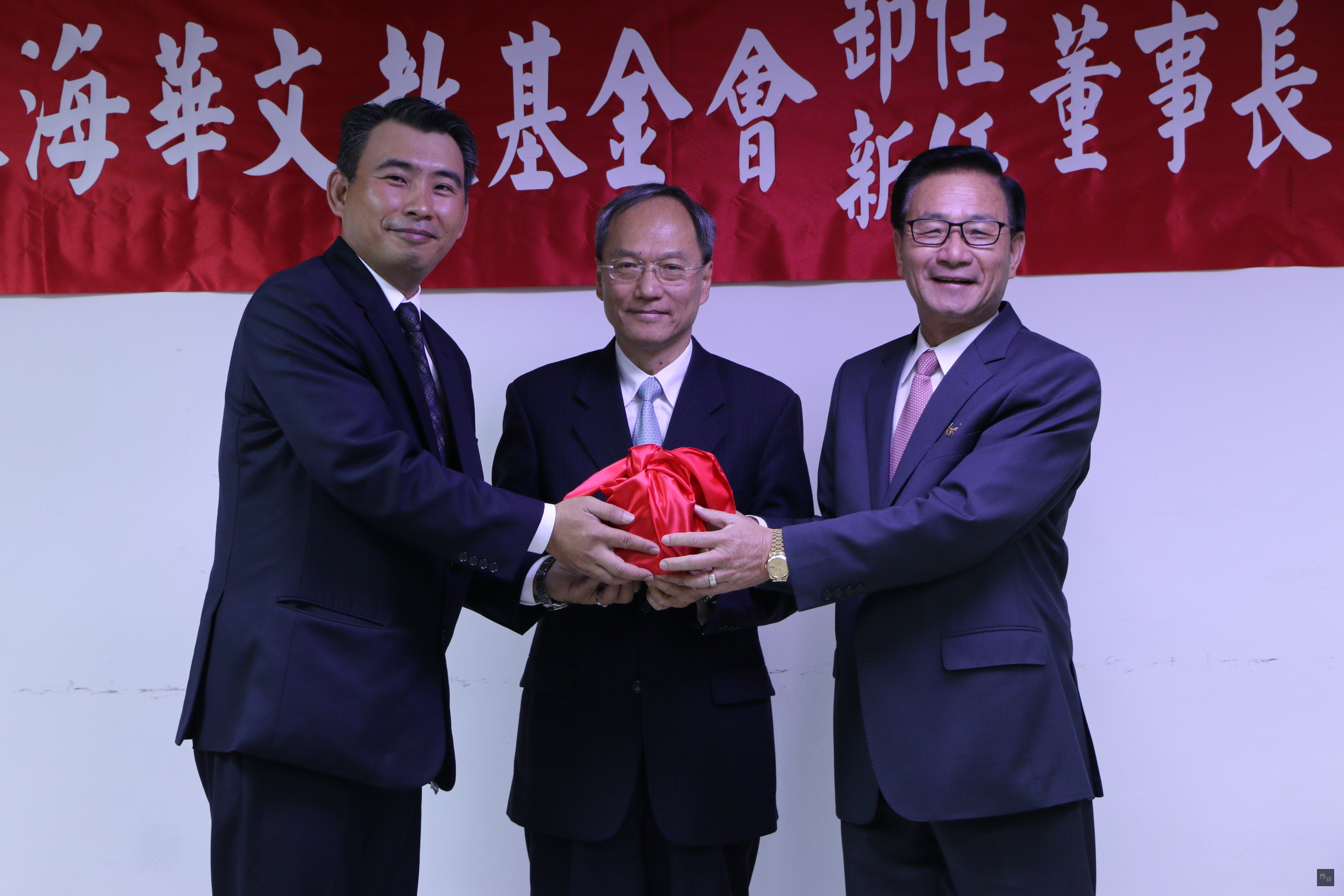 海華文教基金會3日舉行新、卸任董事長交接典禮,由第七屆董事長吳松柏(右)交接給第八屆董事長吳明穎(左),僑務委員會委員長吳新興(中)監交。