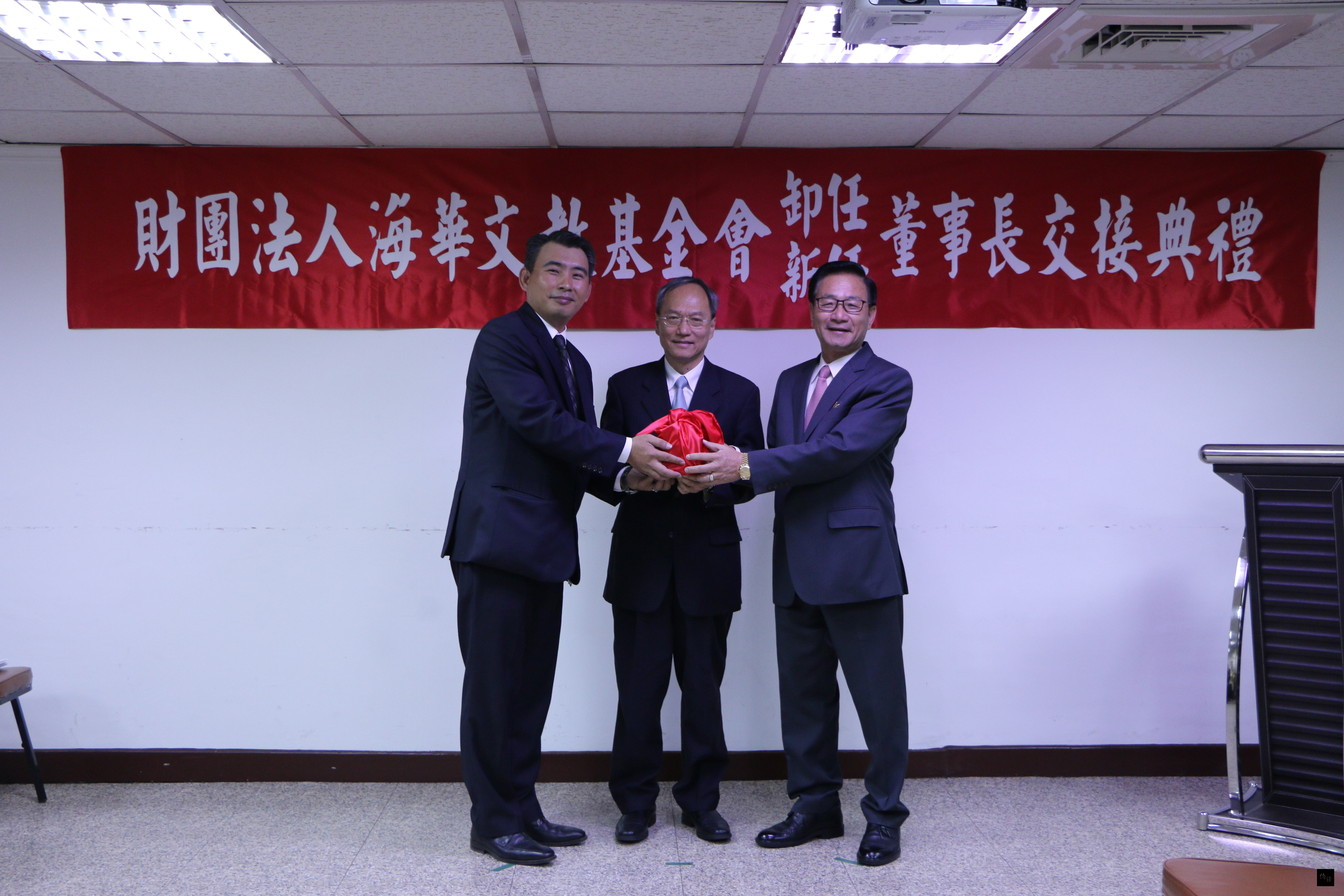 海華文教基金會3日舉行新、卸任董事長交接典禮,由第七屆董事長吳松柏(右)交接給第八屆董事長吳明穎(左),僑務委員會委員長吳新興(中)監交。