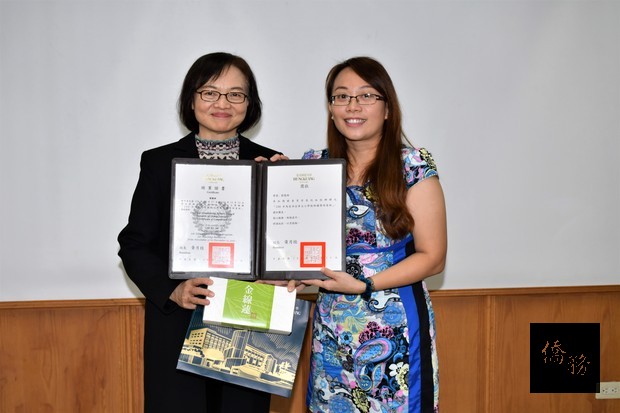 弘光科技大學校長黃月桂（左）頒發畢業證書與紀念品予學員代表黃慧珊（右）。