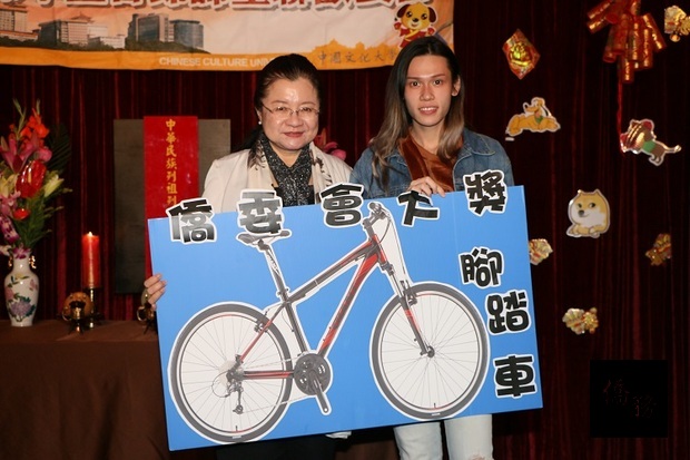 田秋堇(左)抽出摸彩最大獎單車得主一名，和中獎學生合影。