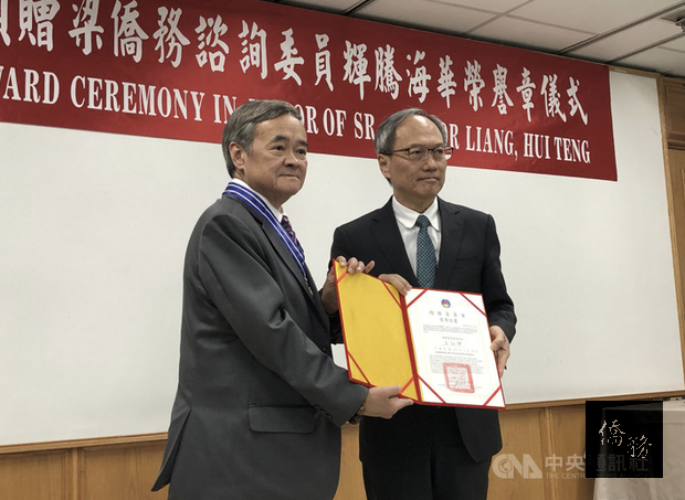 僑委會委員長吳新興(右)27日頒發海華榮譽章給旅墨多年的僑務諮詢委員梁輝騰,表彰他長久以來協助僑務工作,並提供急難救助的協助。/中央社提供