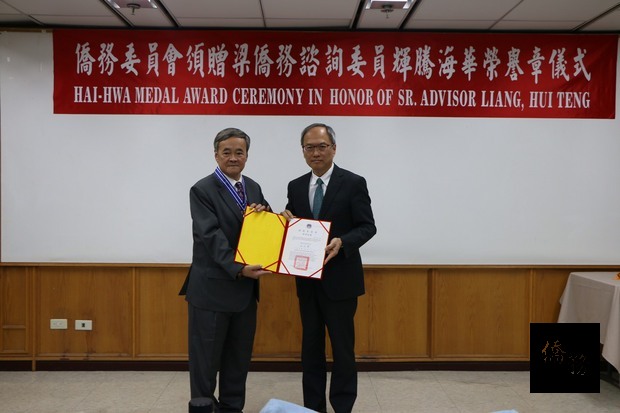 吳新興(右)頒發海華榮譽章及證書給梁輝騰(左)。