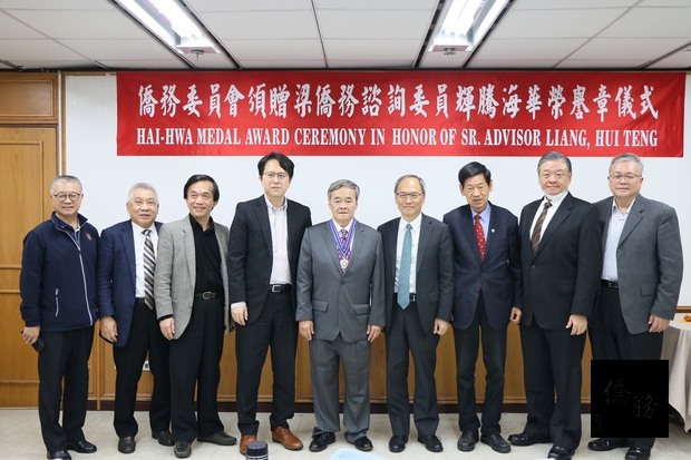 吳新興(右4)、立法委員邱志偉(左4)及僑務榮譽職人員共同見證梁輝騰(中)受頒海華榮譽章。