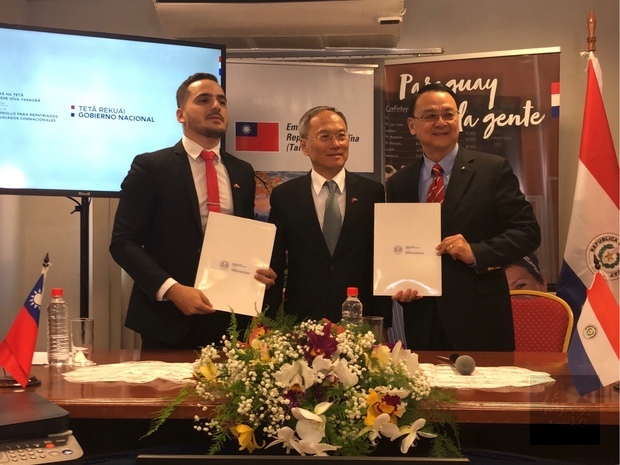 周麟(右)與Ruiz(左)在吳新興(中)見證下交換捐贈議事錄。