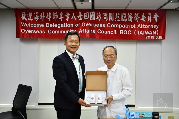 吳新興(右)致贈紀念品,由張宣業(左)代表接受。