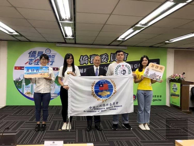 吳新興授旗給四個團隊，感謝青年代表僑委會前往海外進行志工服務
。