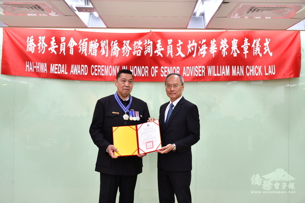 吳新興(右)頒贈海華榮譽勳章及獎狀予劉文灼(左)。