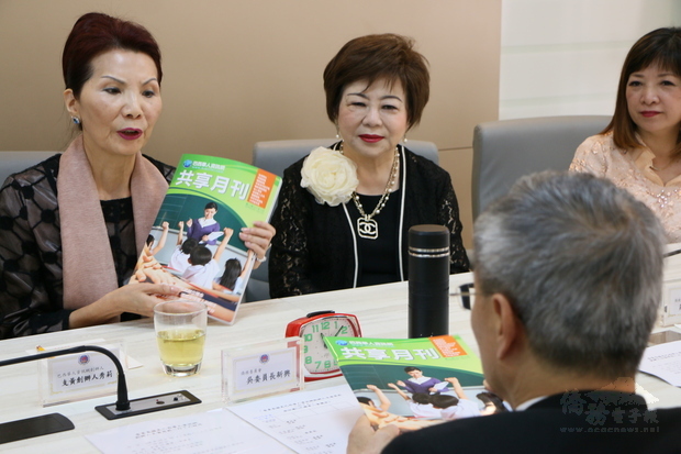 支黃秀莉（左）向吳新興介紹《共享月刊》。