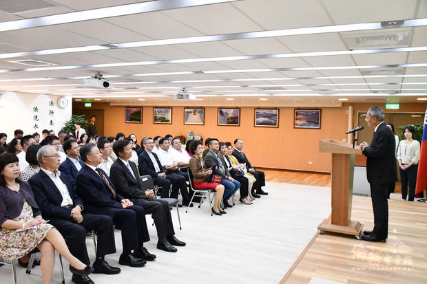 吳新興（站立者）肯定何素珍在泰國僑界與當地社會的付出，她可以說是泰國僑界的模範，因此獲頒玉山僑務獎章是實至名歸。